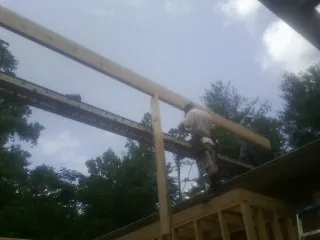 Carpenter setting a ridge beam over a new addition frame — Ice Dam Removal by Roofing Brothers in Calverton