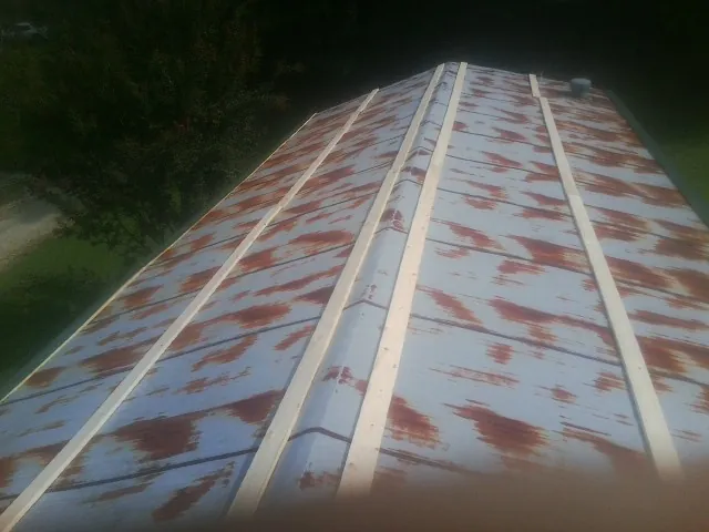 Rusted metal roof panels with new wood purlins before replacement — Storm Damage Roof Repair in Calverton by Roofing Brothers