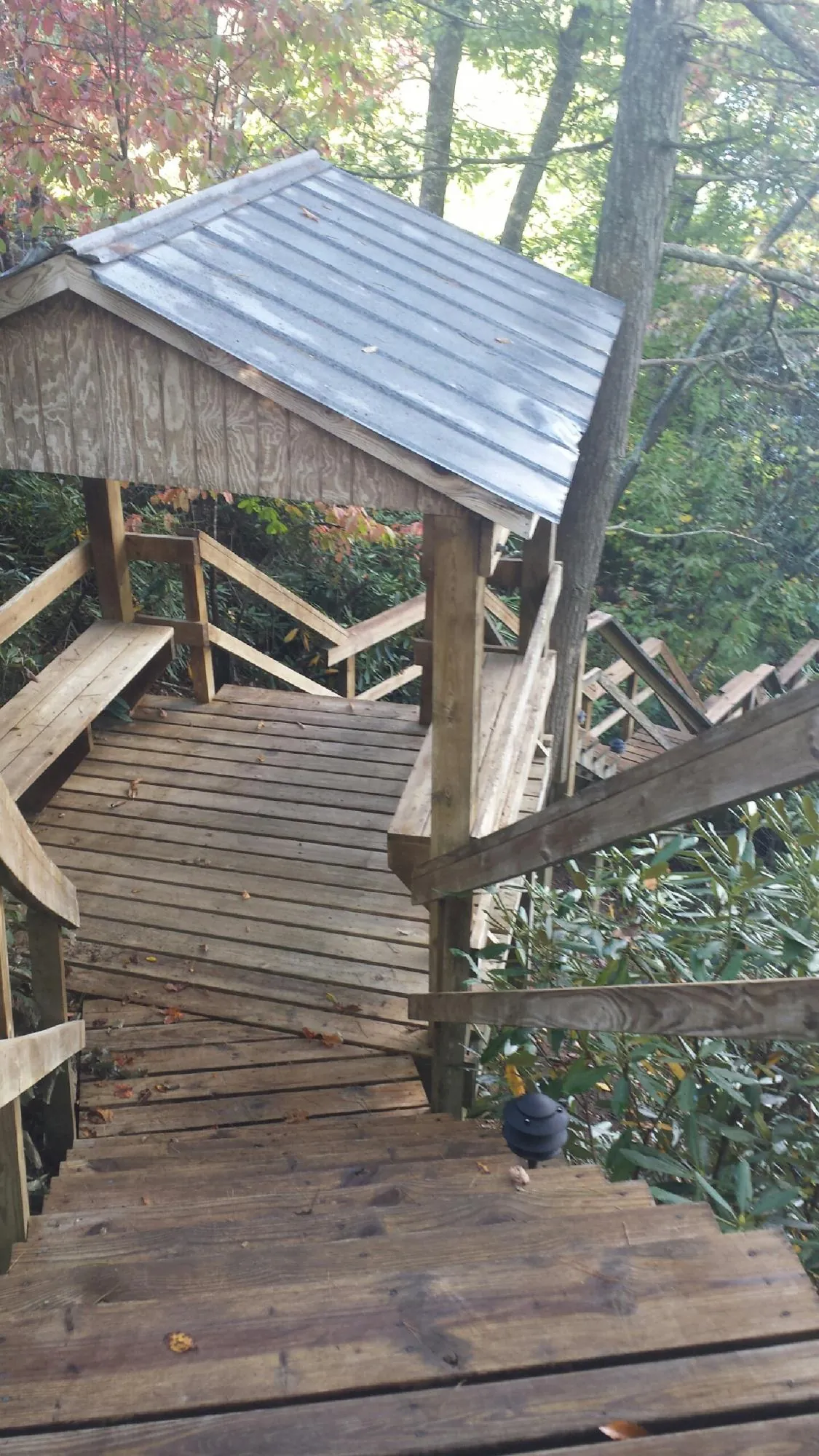 Metal roofed shelter over wooden steps on a wooded walkway — Skylight Repair & Installation work by our crew in Calverton