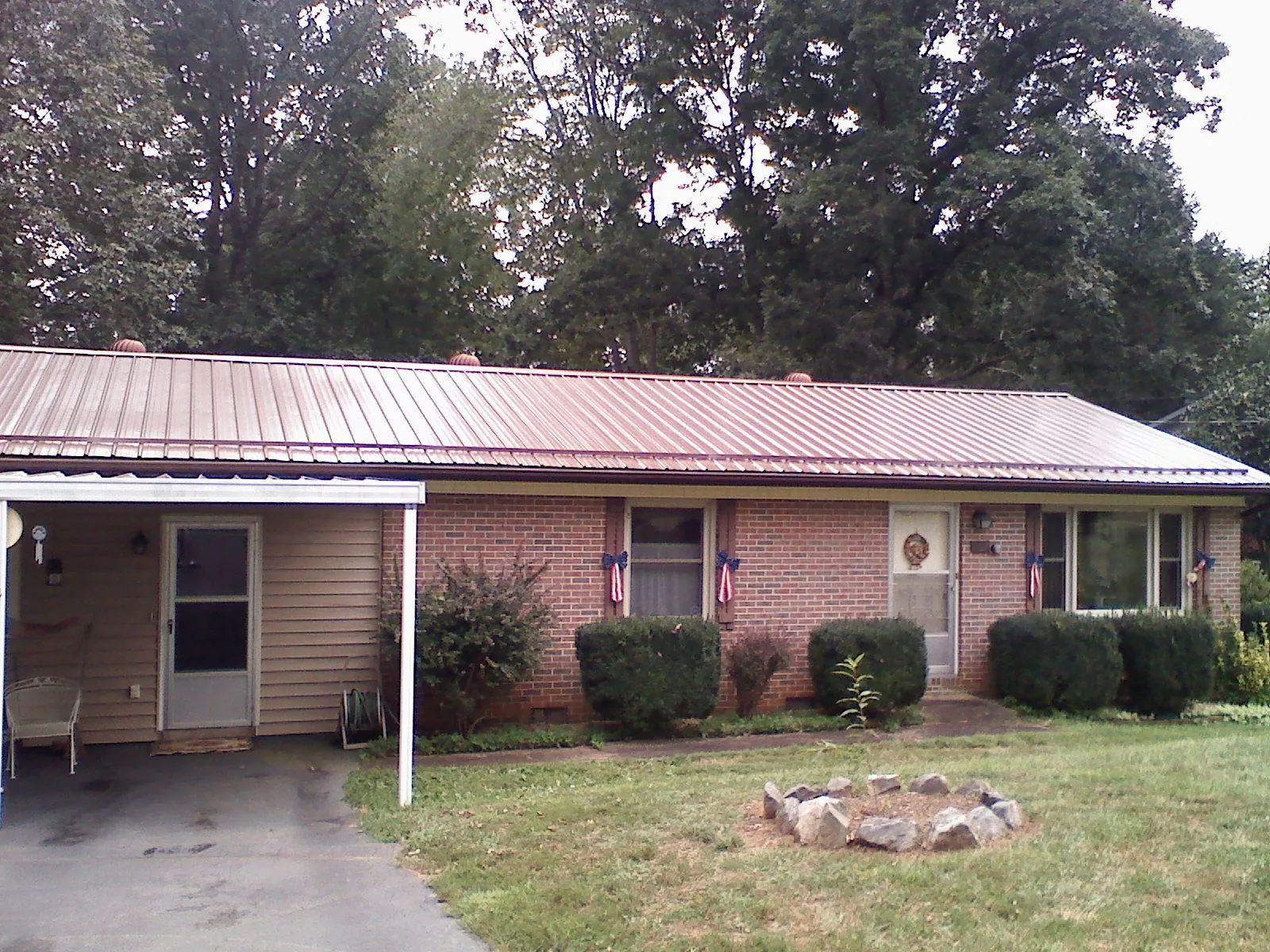 Bronze metal roof and carport on a brick ranch home — Roof Repair work by our crew in Calverton